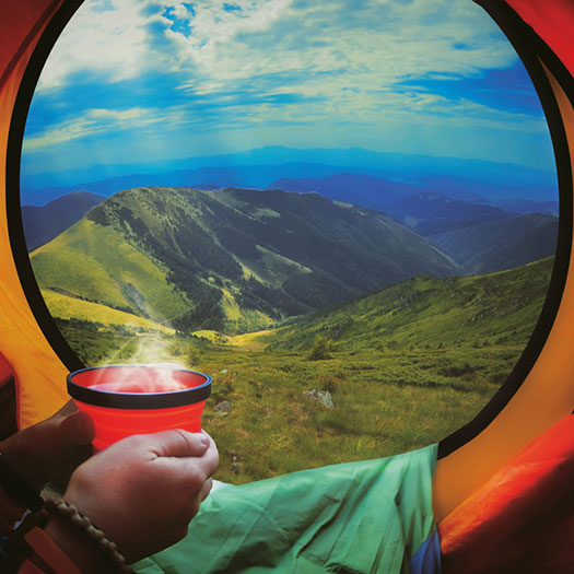 woman lying in a tent with coffee